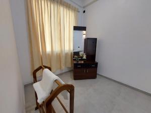 a room with a chair and a dresser and a mirror at Paboda Residency in Minuwangoda