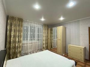 a bedroom with a large bed and a window at Хромтау in Khromtaū