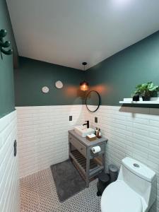 a bathroom with a white toilet and a sink at Hotel ënxë habitación grande camas queen in Cuetzalán del Progreso