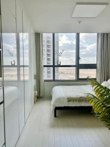 ein Schlafzimmer mit einem Bett und einem großen Fenster in der Unterkunft 송도 한라웨스턴파크, 레지던스형 숙소 in Taeam