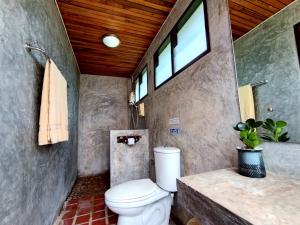 a bathroom with a toilet and a sink and window at Phakphing Erawan Homestay - พักพิง เอราวัณ โฮมสเตย์ in Tha Kradan +38 photos