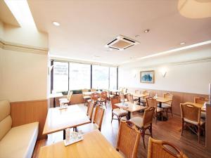 a restaurant with tables and chairs in a room at Inuyama Central Hotel in Haguro