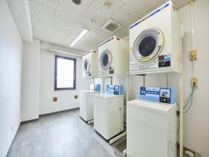 a room with three washing machines on a wall at Inuyama Central Hotel in Haguro