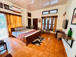 a bedroom with a bed and a desk and windows at Collection O Arya Vidyapeeth College Guwahati in Guwahati +6 photos