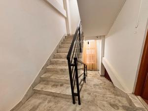 a staircase in a house with a black rail at Collection O Arya Vidyapeeth College Guwahati in Guwahati