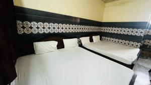 a bedroom with two beds and a black and white wall at Hotel O Mathura Janam Bhumi Link Road in Bhuteshwar