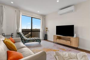 a living room with a couch and a flat screen tv at Its a bit country and a bit town in Karaka