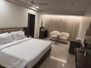 a bedroom with a bed and a desk and chairs at Townhouse Vizianagaram Formerly Happy Stays in Vizianagram City