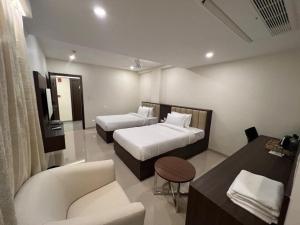 a hotel room with two beds and a couch at Townhouse Vizianagaram Formerly Happy Stays in Vizianagram City