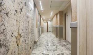 a corridor of a hallway with a stone wall at Townhouse Oak CSJMU Kanpur Formerly Shree Dev Villa in Kaliānpur