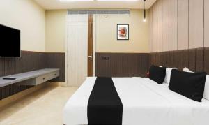 KaliānpurにあるTownhouse Oak CSJMU Kanpur Formerly Shree Dev Villaの大きなベッドとテレビのある寝室