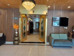 a hallway with a chair and a television in a building at Collection O Uttaranchal University Premnagar in Jhājra