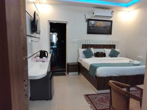 a bedroom with a bed and a sink in it at Collection O Uttaranchal University Premnagar in Jhājra +25 photos
