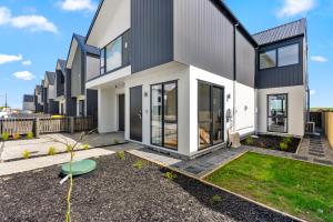 a modern house with large windows and a yard at Its a bit country and a bit town in Karaka