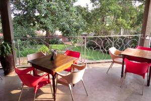 a patio with wooden tables and chairs and a balcony at Dutchess Hotel and Restaurant in Fort Portal