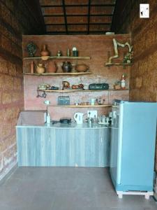 Ein Zimmer mit einer Arbeitsfläche, an deren Wand Töpfe und Pfannen stehen. in der Unterkunft Coffee Voyages in Madikeri