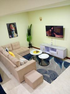 a living room with a couch and a table at Spacious Calitwapa Studio Apartment with AC and Private cook upon request available in Mtwapa