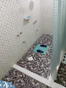 a bathroom with a shower with a floor of rocks at Spacious Calitwapa Studio Apartment with AC and Private cook upon request available in Mtwapa