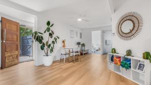 - un salon blanc avec une table et un miroir dans l'établissement The Infinite Pi Escape, à Bongaree