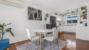 une cuisine et une salle à manger avec une table et des chaises dans l'établissement The Infinite Pi Escape, à Bongaree