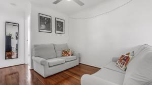 un salon avec un canapé et une chaise dans l'établissement The Infinite Pi Escape, à Bongaree