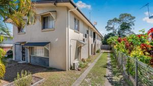 un immeuble d'appartements avec une clôture donnant sur un jardin dans l'établissement The Infinite Pi Escape, à Bongaree 16 autres photos