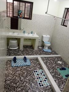 a bathroom with a sink and a toilet at Spacious Calitwapa Studio Apartment with AC and Private cook upon request available in Mtwapa +23 photos