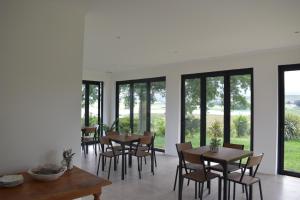 a dining room with tables and chairs and windows at Mable's BnB 