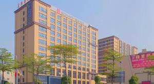 a tall building with trees in front of it at Echarm Hotel Foshan West Station Shishan Luocun in Luocun