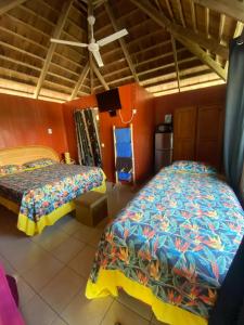 um quarto com 2 camas e uma cozinha em Monita Villa Rangiroa em Tiputa
