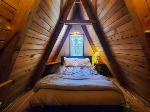 a bed in a room in a wooden attic at Douglas Island A-frame Cabin in the woods in Juneau International Airport