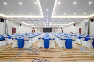 een grote feestzaal met witte en blauwe tafels en stoelen bij Echarm Plus Hotel Nanning Convention and Exhibition Center Medical University in Nanning