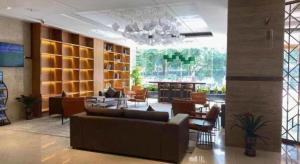 een lobby met een bank en stoelen en een bar bij Echarm Plus Hotel Nanning Convention and Exhibition Center Medical University in Nanning