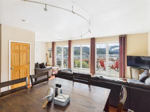 a living room with a couch and a table at Juneau Oceanfront Home Overlooking Auke Bay in Mendenhaven