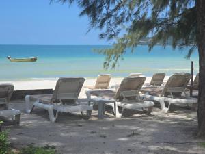 a group of chairs and tables on the beach at White Beach Hostel in Koh Rong Island +21 photos