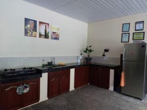 a kitchen with wooden cabinets and a stainless steel refrigerator at Mountain Side Travellers Inn in Zambales