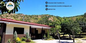 a building with a mountain in the background at Mountain Side Travellers Inn in Zambales