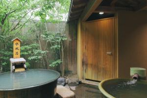 a bathtub in a room with a pool of water at 四季の宿 明翠 in Kirishima +18 photos