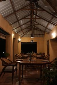 a dining room with a table and chairs and a projection screen at Sakhua stays in Tāla