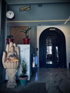 a hallway with a clock on the wall and a plant at Blackout Bar & Hotel in Hanumāngarh Junction