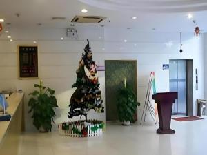 een kerstboom in het midden van een kamer bij Yidun Hotel Foshan Luocun in Huanshi