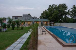 a swimming pool in front of a house at The Sawai Heritage in Sawāi Mādhopur