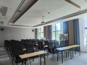 een kamer met rijen tafels en stoelen bij Echarm Hotel Zhuzhou Liling in Li-ling-hsien