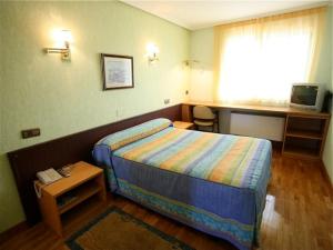 ein kleines Hotelzimmer mit einem Bett und einem Tisch in der Unterkunft El Alfoz de Burgos in Villagonzalo-Pedernales