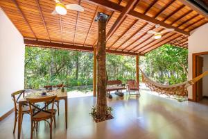 a room with a table and chairs and a tree at Casa alto padrão próximo a praia, suíte, jacuzzi in Marau