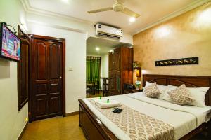 ein Schlafzimmer mit einem großen Bett, einem Fernseher und einem Fernseher in der Unterkunft Hotel Mart View in Kochi