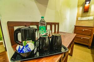 ein Tablett mit Kaffeekannen und einer Flasche Wasser in der Unterkunft Hotel Mart View in Kochi