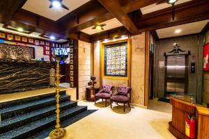 ein Zimmer mit zwei lila Stühlen und einer Treppe in der Unterkunft Hotel Mart View in Kochi