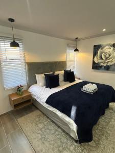 ein Schlafzimmer mit einem großen Bett mit schwarzen Decken und Kissen in der Unterkunft Peaceful and Luxurious Hidden Cove in Gqeberha + 13 Fotos