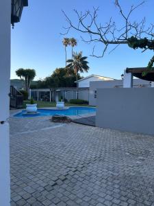ein Schwimmbad in einem Hof neben einem Haus in der Unterkunft Peaceful and Luxurious Hidden Cove in Gqeberha